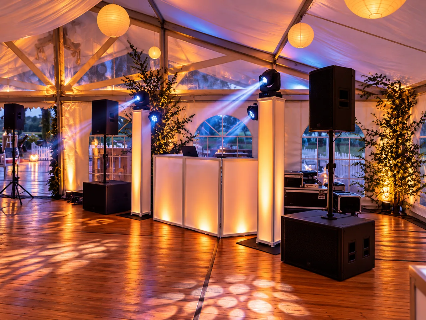DJ-Booth mit weißen Lichtsäulen und Beschallungsanlage im stimmungsvoll beleuchteten Festzelt